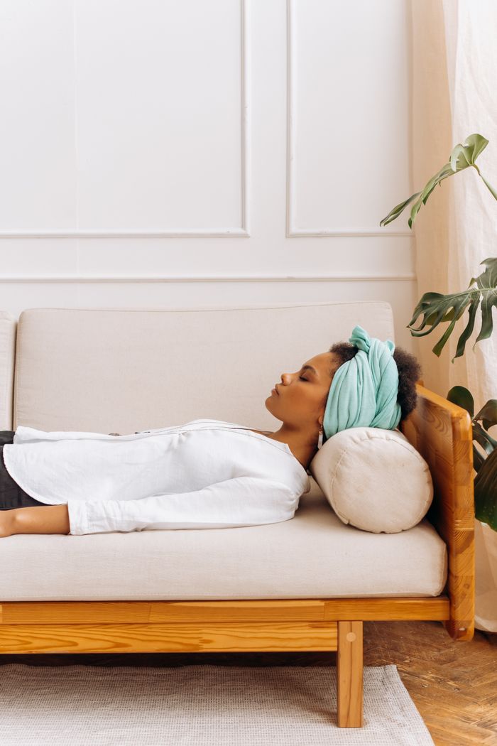 A woman peacefully resting on a sofa, showcasing a calm and serene indoor setting.